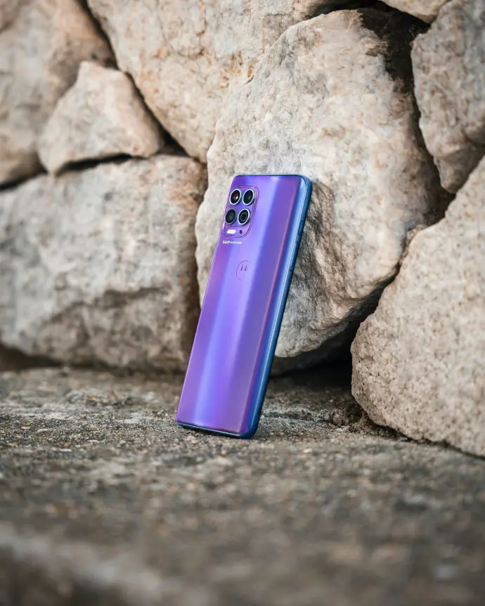 a purple cell phone sitting on top of a rock